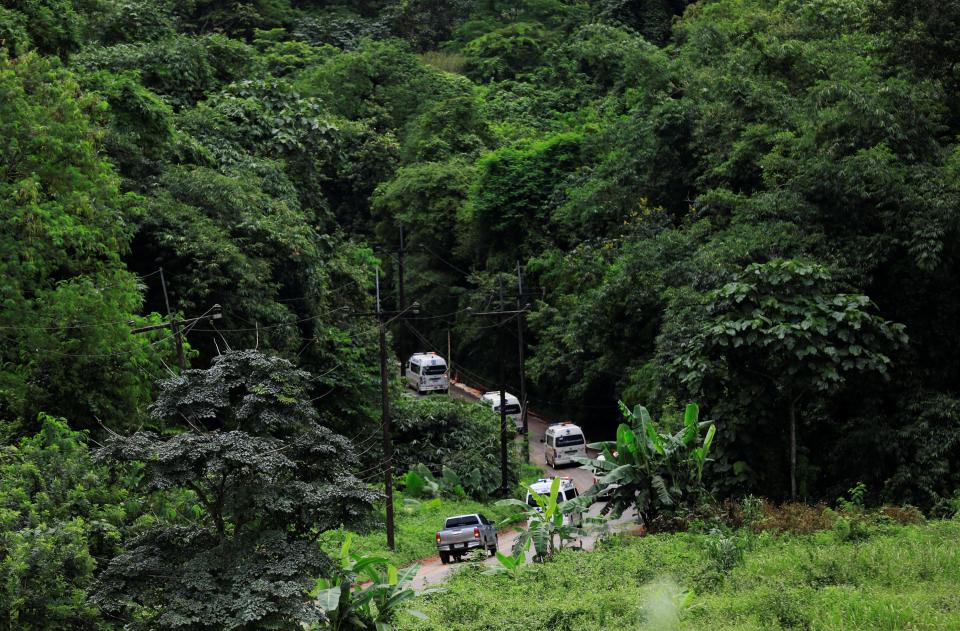  A convoy of emergency vehicles snakes through the forest near the cave complex