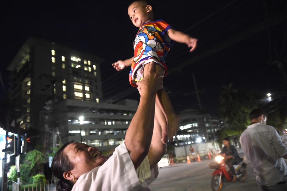  A woman hoists her baby above her head in celebration after the boys are rescued from the cave in Thailand