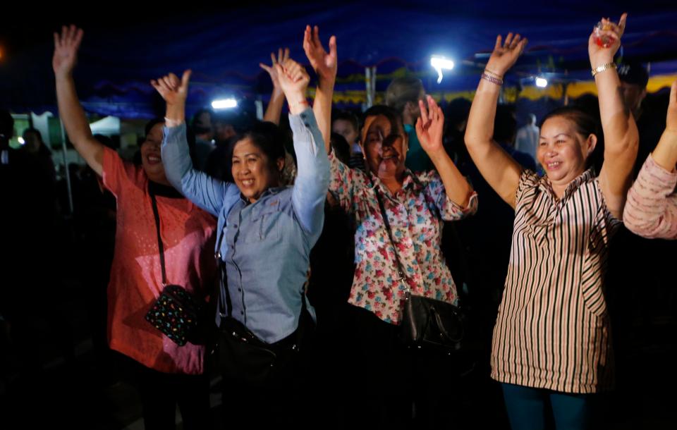  A group of women raise their arms in delight after news of the rescue broke