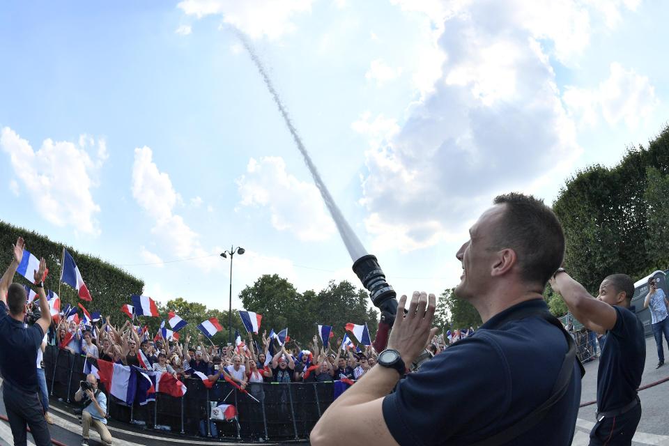 Someone fires a fireman's hose into screaming French fans as they celebrate World Cup win