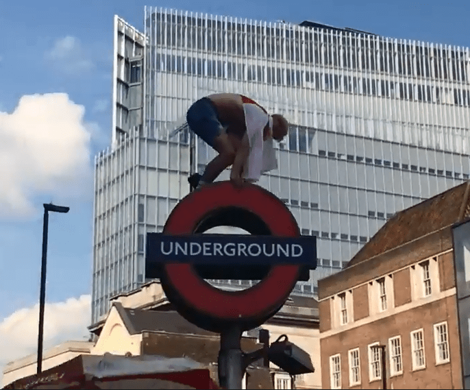  Overground... this lad climbs on TOP of an underground sign outside London Bridge tube station