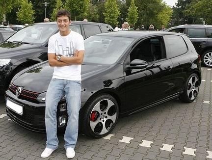 A young looking Mesut Ozil poses with his Volkswagen 