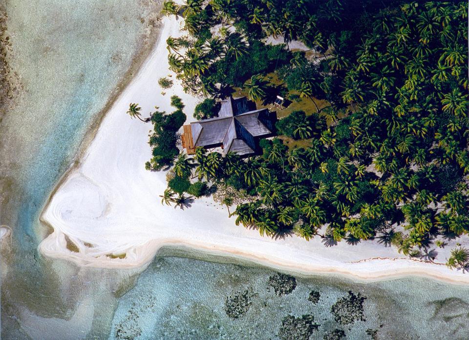  Aerial photos show the island's building, palm tree forest and white sand beach from above