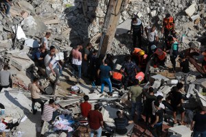  Palestinian paramedics search for survivors under the rubble of a destroyed building in Gaza City on May 16