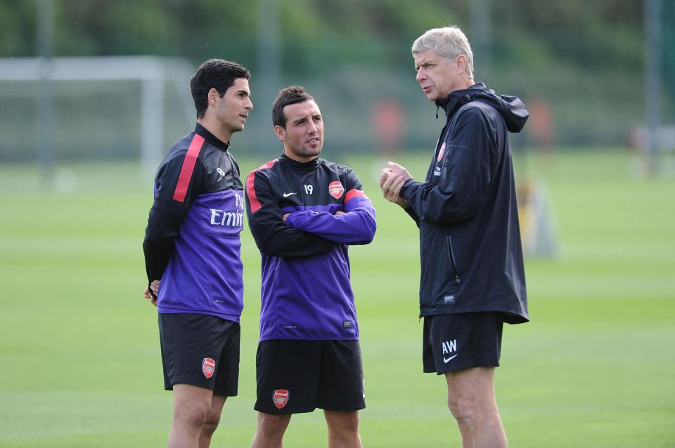  Arsene Wenger talks with Mikel Arteta and Santi Cazorla during a training session at London Colney