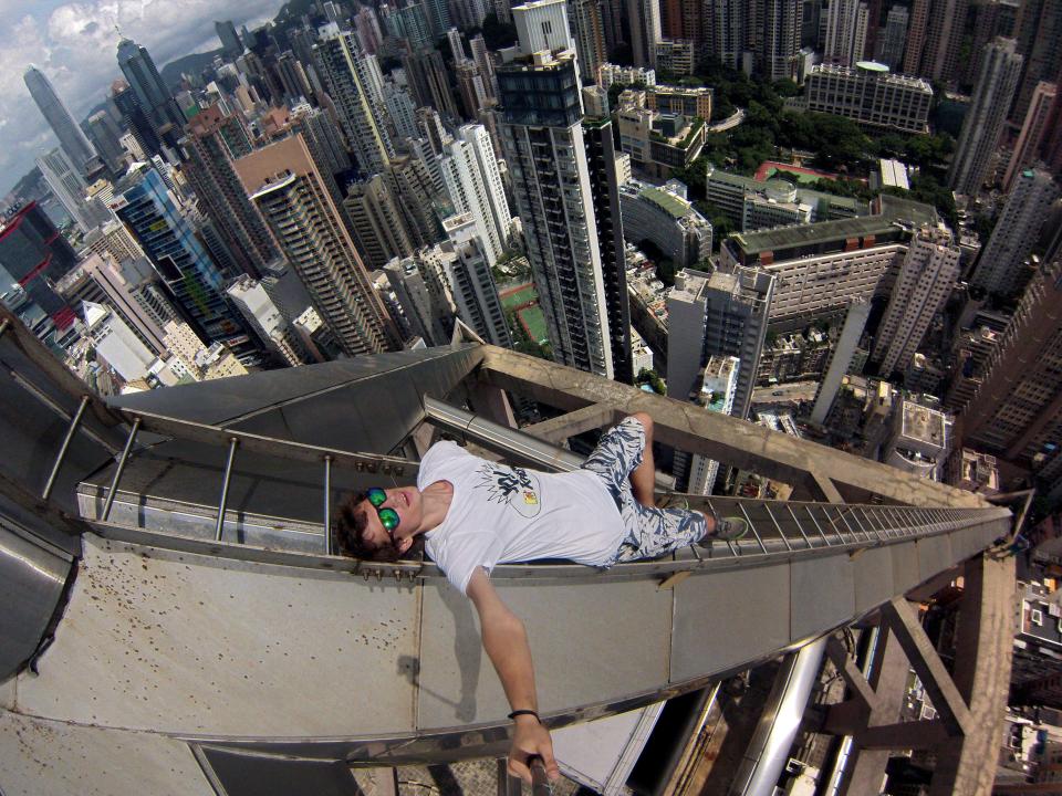  Alexander Remnos uses a selfie stick to take a picture standing on a ladder on a Hong Kong skyscraper