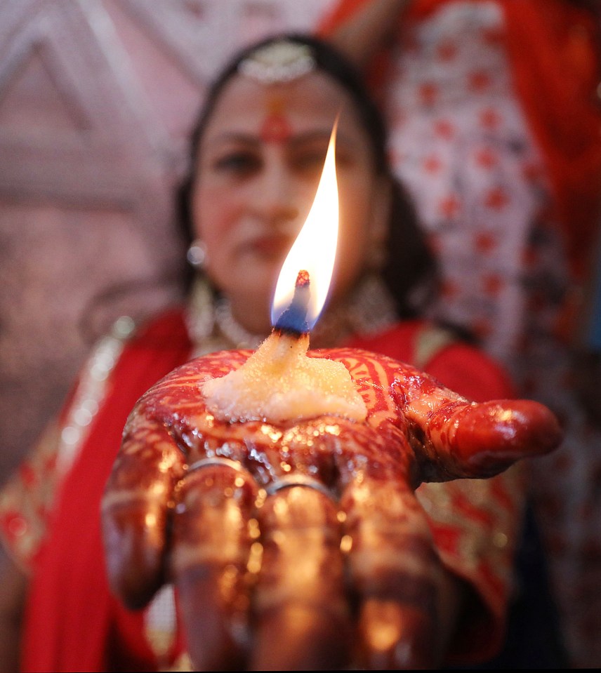  A woman offers prayers at a Hindu Chamunda Devi temple on the first day of Navratri