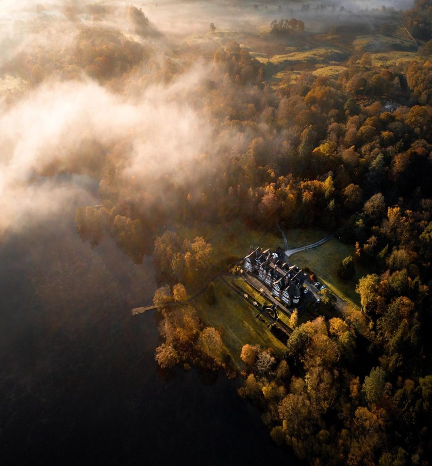 A house tucked away in between numerous trees pictured in the Lake District