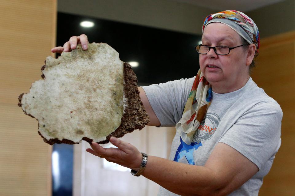 Ms Gonzales holds up another piece of a plane, said to be part of the missing MH370