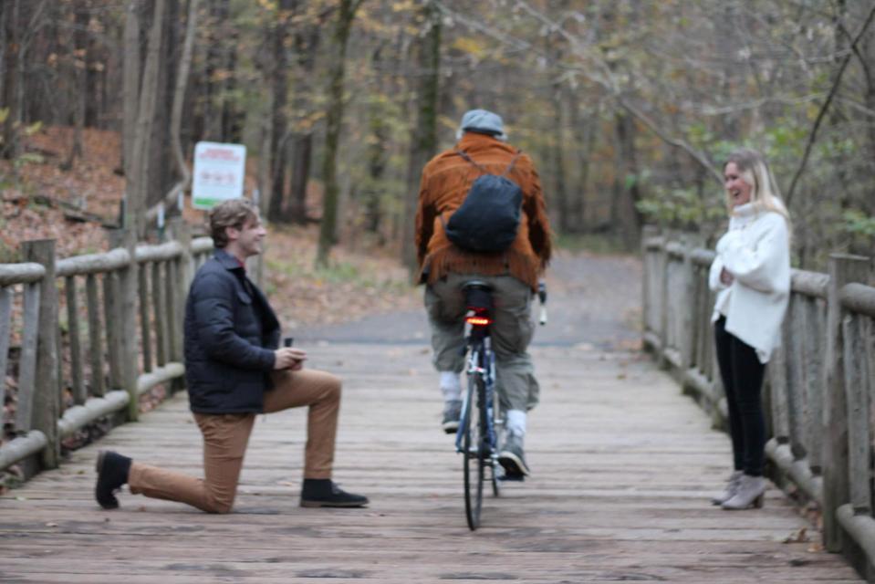 An oblivious cyclist rides past at the moment Blake is about to pop the question