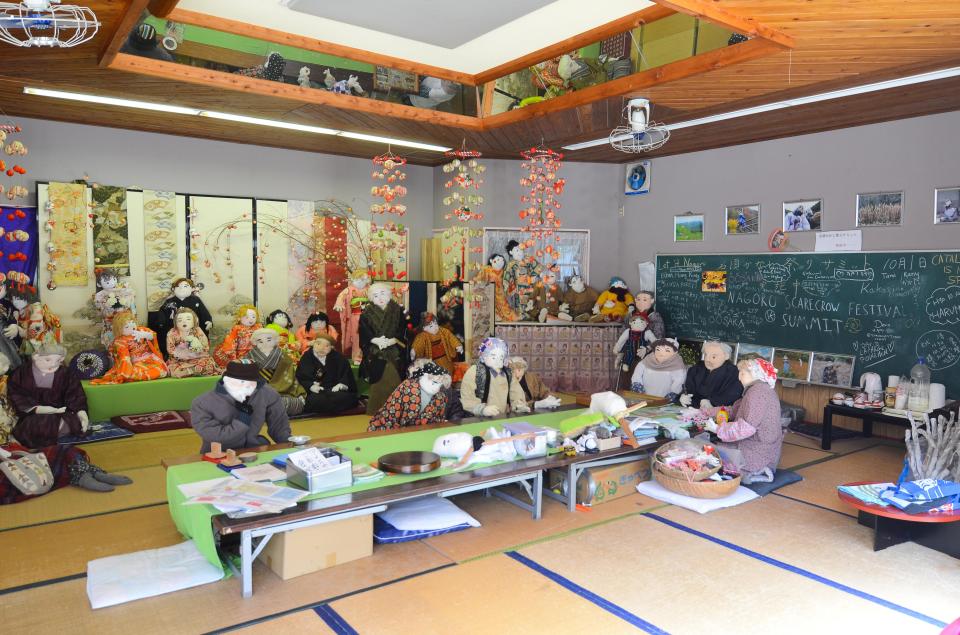  Many dolls sit together completing activities in the community centre