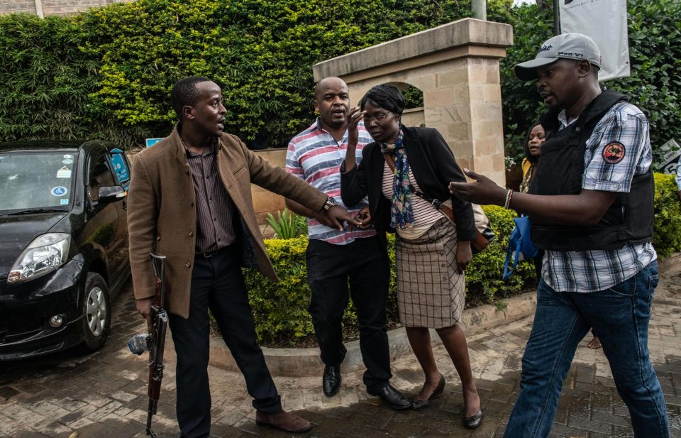 A woman is led to safety amid the harrowing gun battle