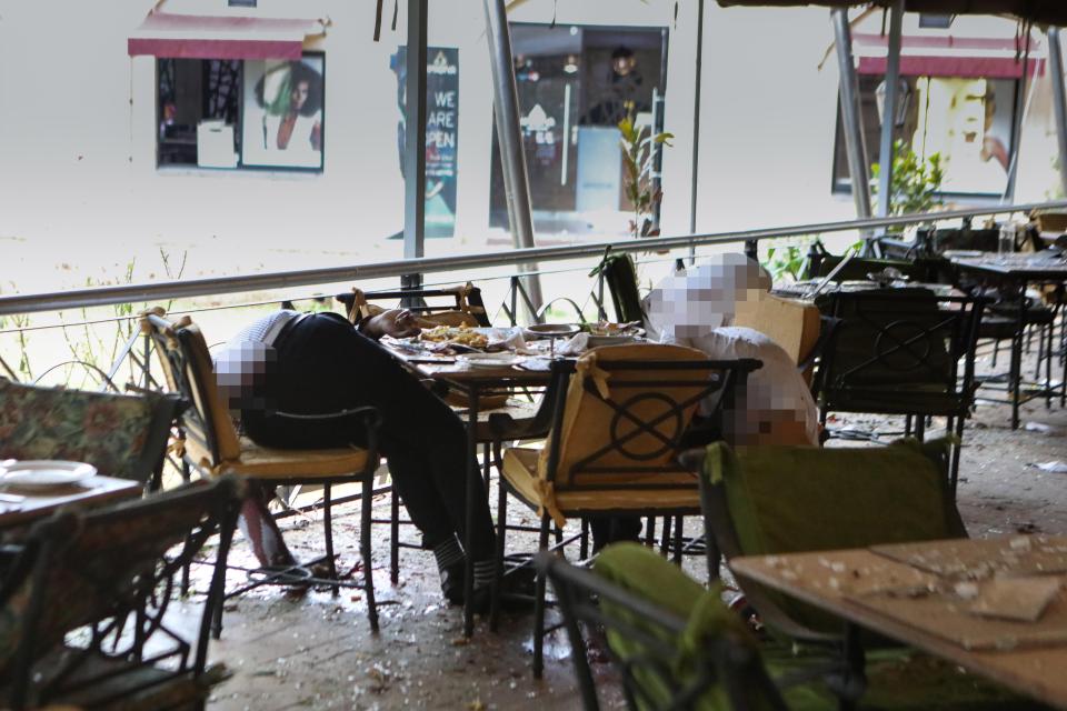 Bodies lie slumped where they sat at the hotel following the horrific attack