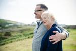 a man is hugging a woman in a field