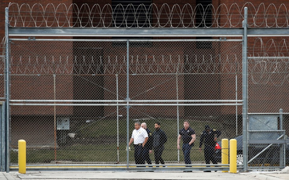  The actor, dressed all in black in the centre, is escorted to the court's gates