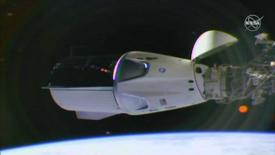 The SpaceX Crew Dragon spacecraft docked at the International Space Station for the first time today, pictured attached to the station's Harmony module as Earth rotates below
