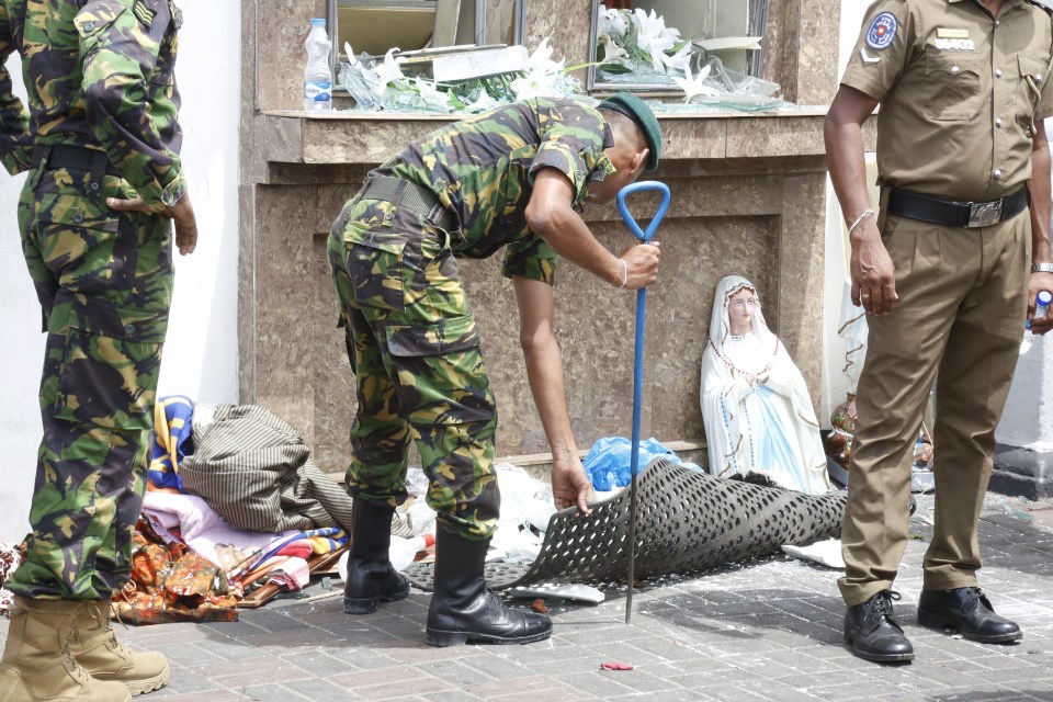  A soldier picks through the destruction outside a church targeted in a horrifying attack