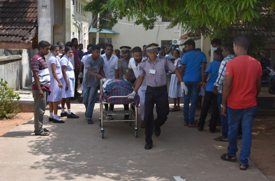  Stunned witnesses look on as a victim is wheeled to get medical help following one of the attacks in Colombo