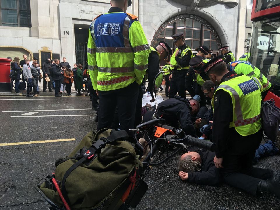  Police officers work to untie the protesters who glued themselves together on Fleet Street