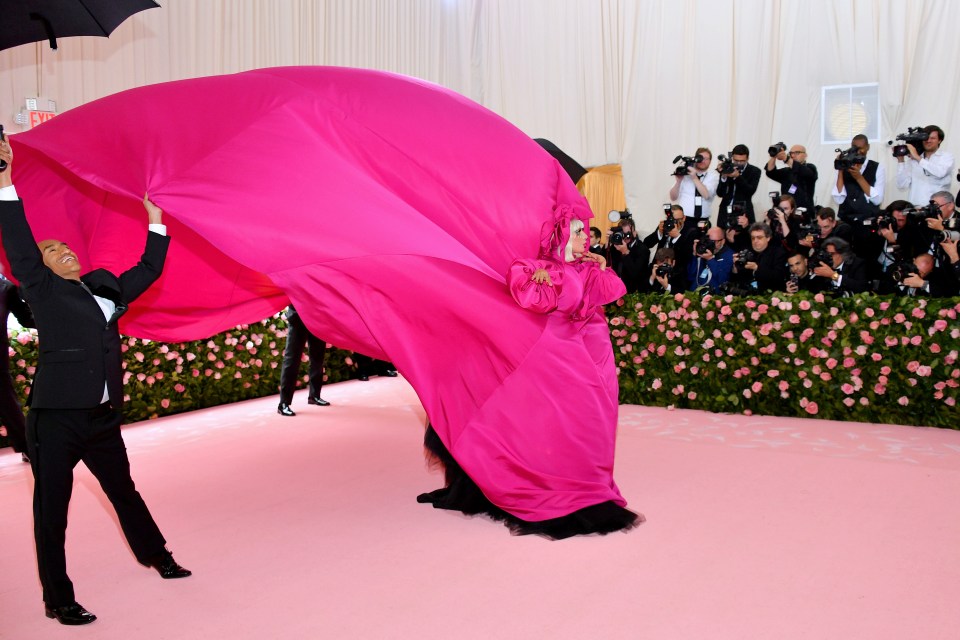  Her helpers lifted her dress into the sky before unbuttoning her