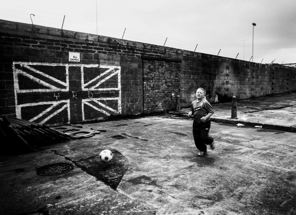  This little lad is having a kick about, with the goal being a huge Union Jack flag