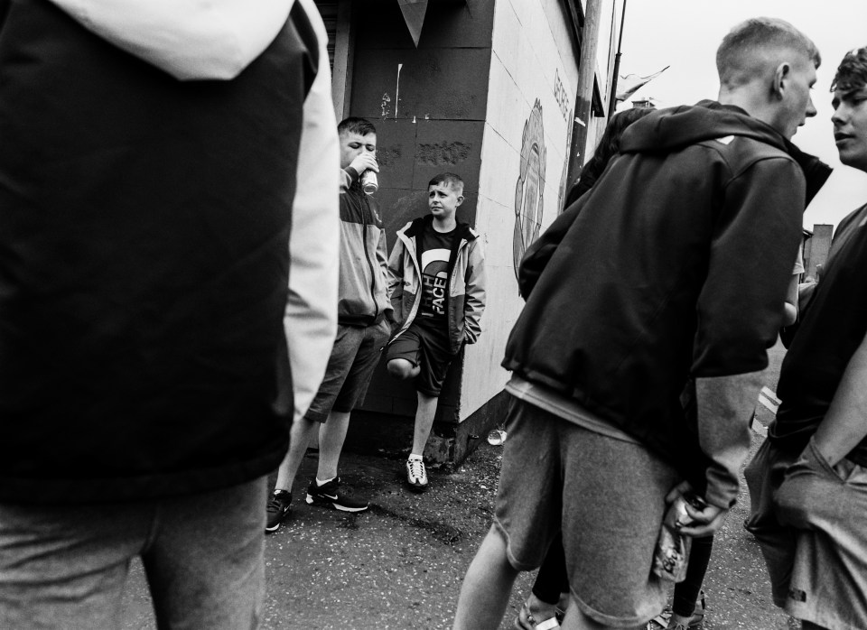  Boys drinking beer from tins start scrapping outside a community centre