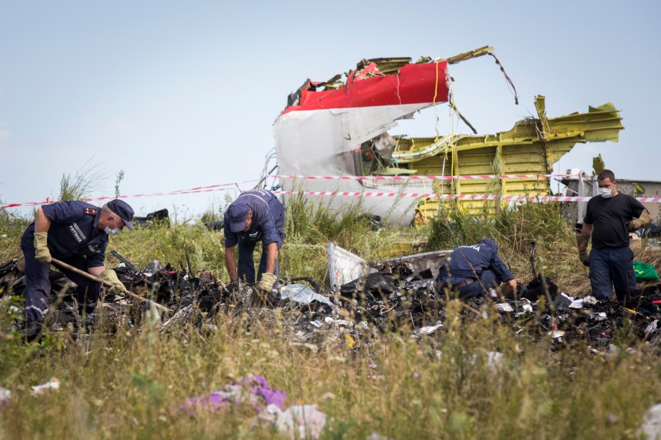 Air crash investigators inspect the crash site in a filed in Ukraine