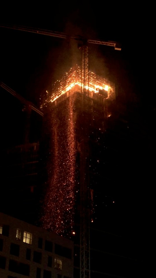  The top floors of a skyscraper are seen engulfed in flames
