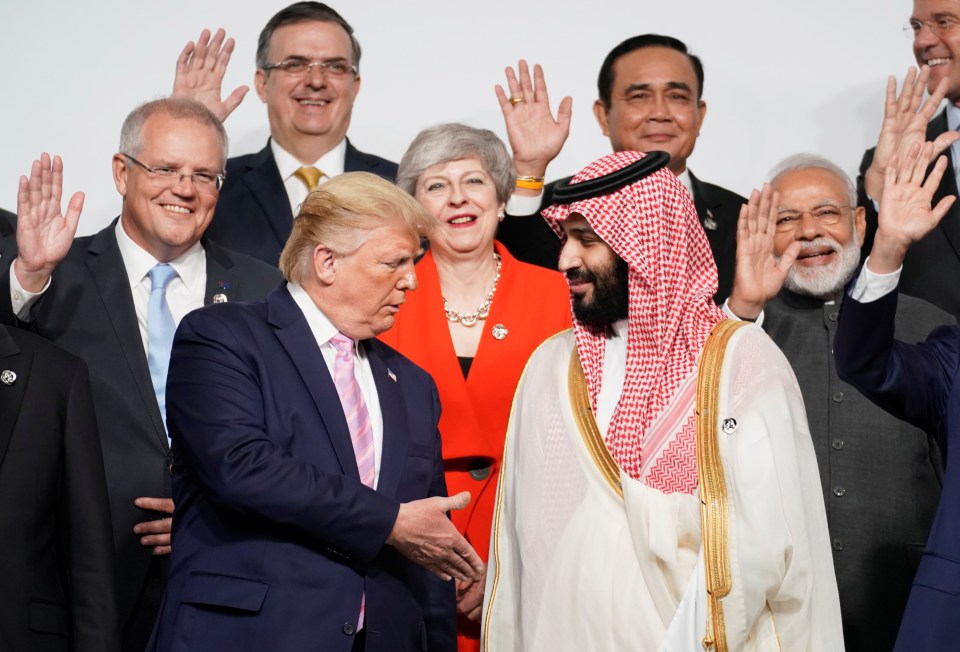 Prime Minister Theresa May can be seen standing behind Donald Trump and Saudi Arabia's Crown Prince Mohammed bin Salman during the group photo
