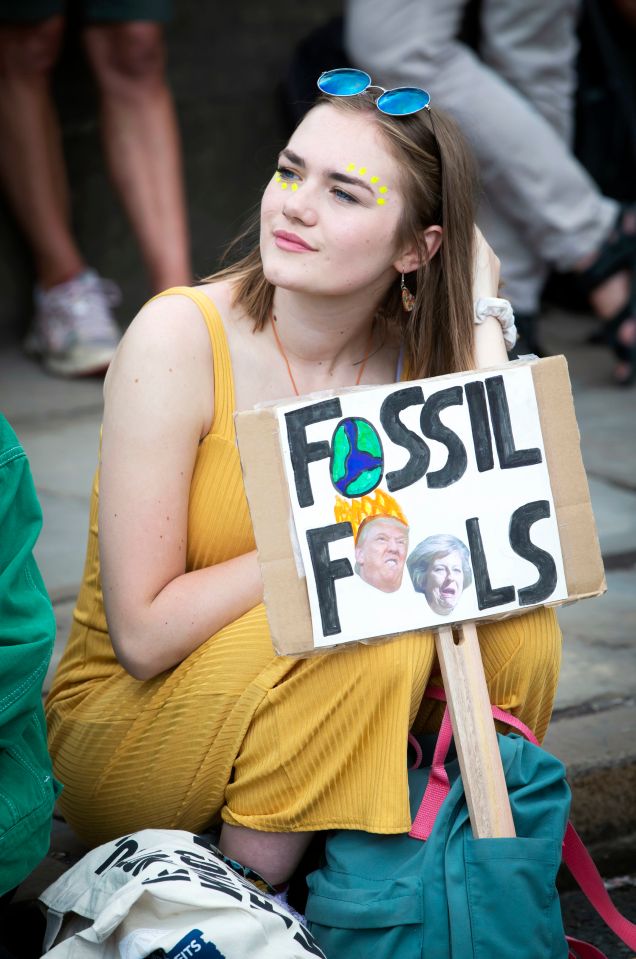 A woman holds this sign with Donald Trump and Theresa May's head on it during protests in Leeds