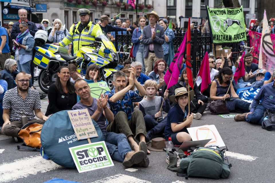 Demonstrators sit on the ground, blocking the road in London