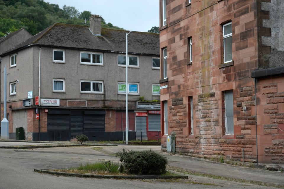Boarded-up shops and homes in an abandoned estate.