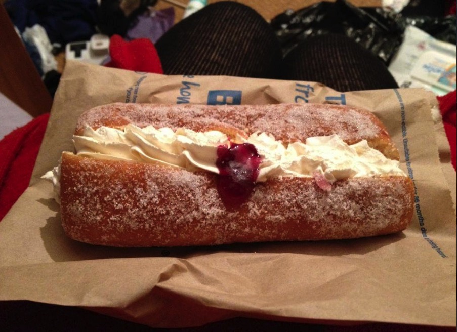  This vanilla doughnut topped with cream looks like a tasty treat
