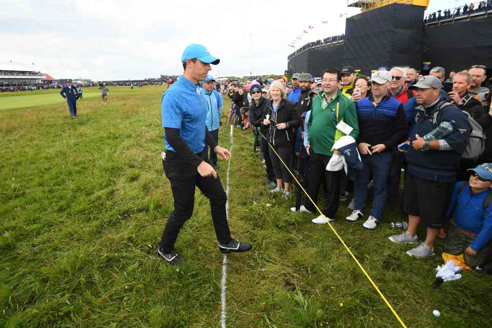  McIlroy picks his ball up from out of bounds after it hit a woman
