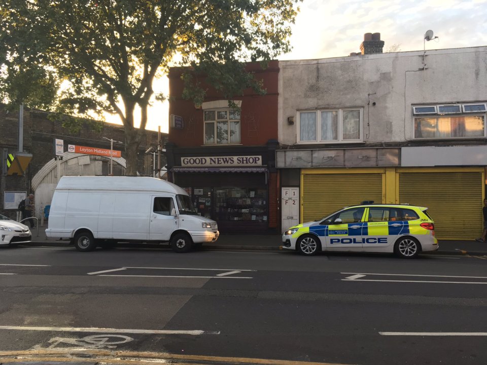 A white van is guarded by a police car after the cop was attacked overnight
