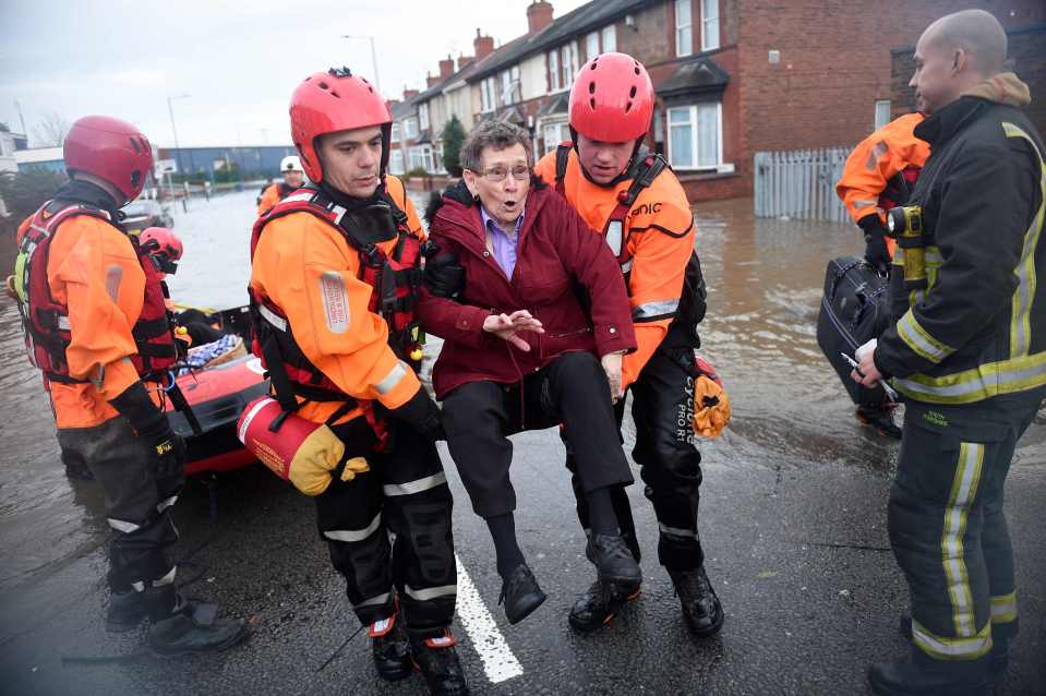 Members of the Fire and Rescue service evacuate an elderly resident to dry land, from a flooded house in the Bentley suburb of Doncaster