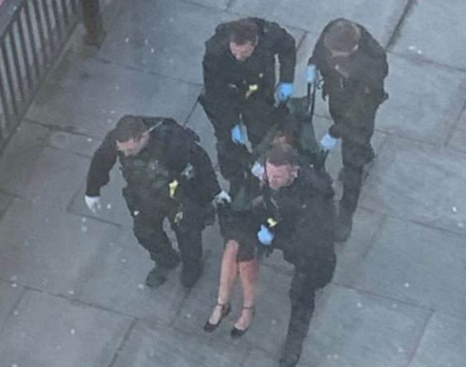 A woman can be seen being carried away from the bridge