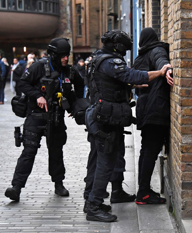 Police can be seen searching a man at the scene