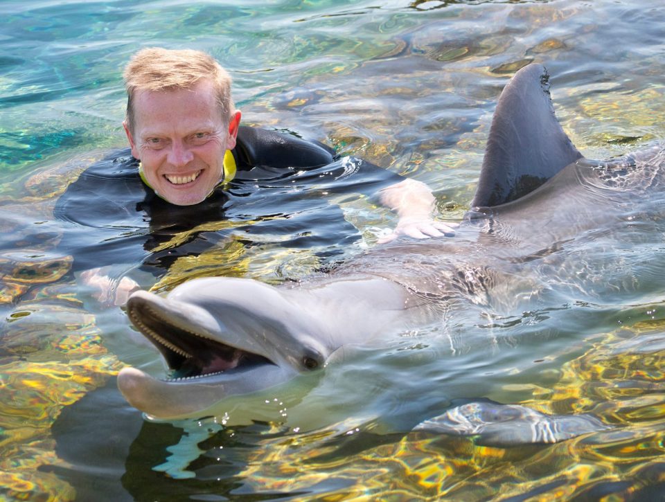 Paul poses with dolphin Kaylei at all-inclusive resort Discovery Cove