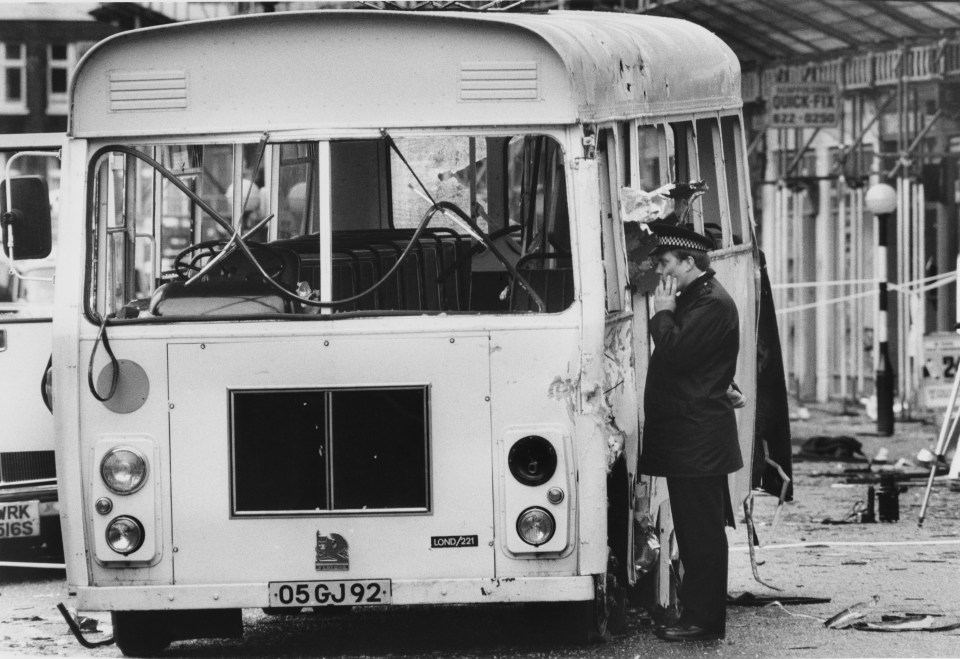  A police officer inspecting a wrecked military bus next to Chelsea Barracks, London, after a nail bomb attack by the Provisional IRA 11th October 1981