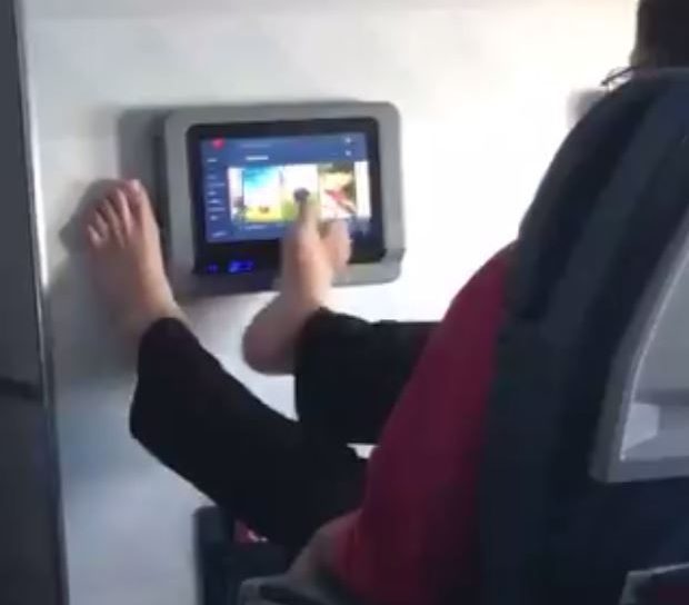 A man was seen using his feet to swipe through the entertainment screen