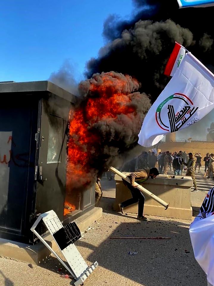 The thugs raised flags of Iran-back militia groups after storming through an outer wall
