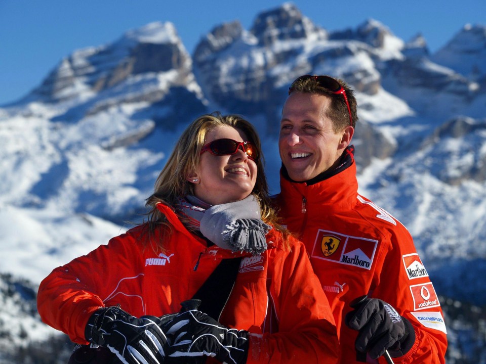 Michael Schumacher and his wife Corinna smile in front of a mountain panorama in the ski resort of Madonna di Campiglio, Italy