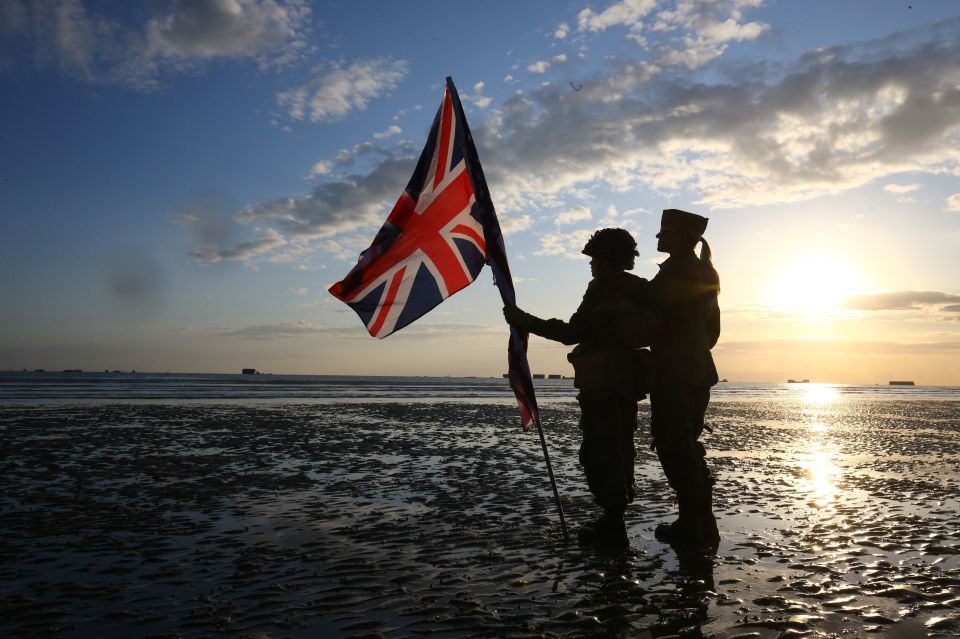  Reenactors dressed in military uniform carry a Union flag at dawn on the beach at Arromanches in Normandy, northern France, ahead of a day of events to mark the 75 anniversary of D-Day