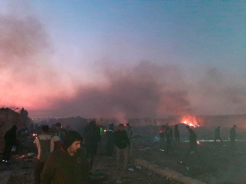 Rescuers are seen at the scene of the crash in the southwestern outskirts of Tehran