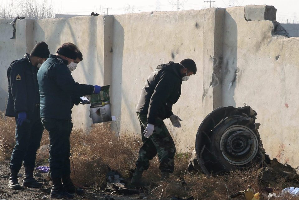 Rescue teams examine what appears to be the wheel of the airliner in the wreckage