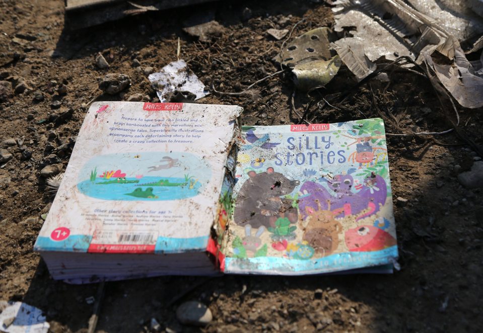  A child's book lies among the wreckage strewn across the ground