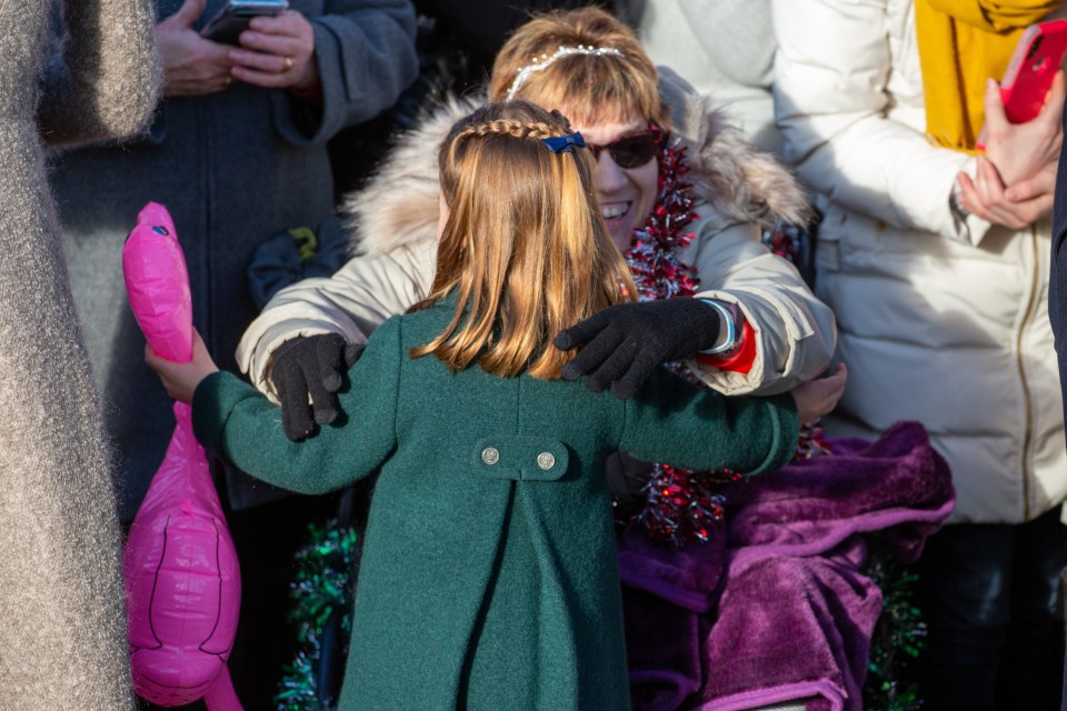 The little royal hugged a fan as they headed into the Sandringham service