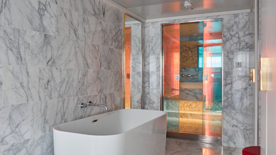 The bathroom in the Rockstar Suite includes a full sized bath tub and marble tiling