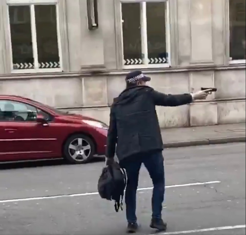  An armed police officer is seen carrying a rucksack at the scene